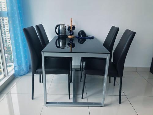einen Tisch mit schwarzen Stühlen und eine Teekanne darauf in der Unterkunft Offer Best Value Studio KSL Residences Daya in Johor Bahru