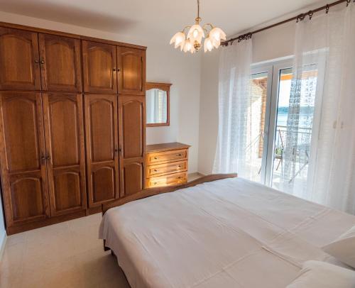 a bedroom with a bed and a dresser and a window at Apartments Anita 1 in Barbat na Rabu