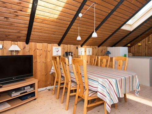 a dining room with a table with chairs and a television at 6 person holiday home in Fårvang in Fårvang
