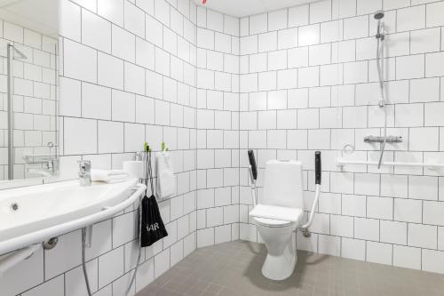 a white bathroom with a toilet and a sink at GreenStar Hotel Vaasa in Vaasa