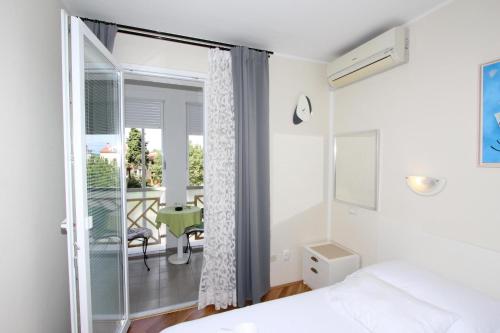 a bedroom with a bed and a view of a balcony at Room Roma in Rovinj