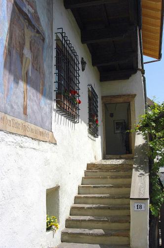 a building with stairs and a painting on the side at Hotel Öhlerhof in Lagundo