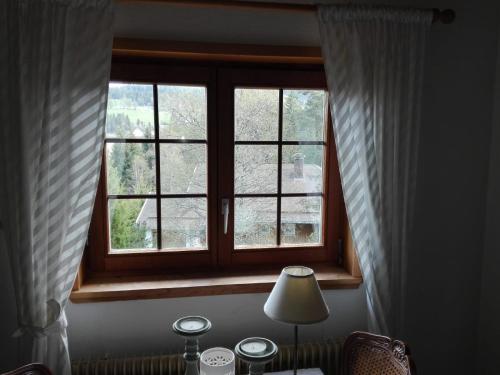 a window in a room with a table with a lamp at Fuchs und Has' Gästehaus in Feldberg