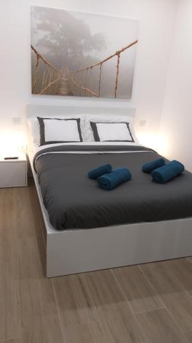 een wit bed met blauwe kussens in een slaapkamer bij Blanco 35 by SunHousesCanarias in El Tablero