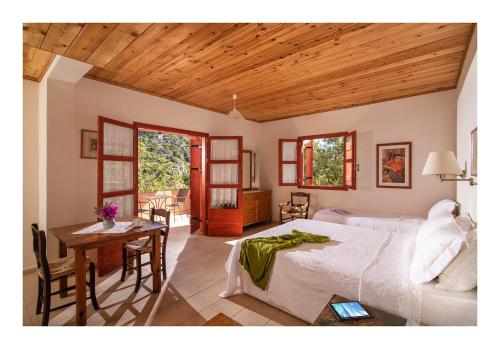 a bedroom with a bed and a table and chairs at Enagron Ecotourism Village in Axós