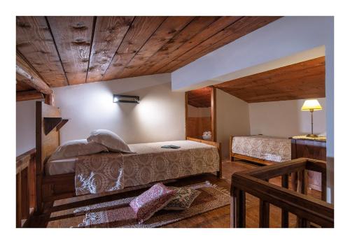 a bedroom with two beds in a room with wooden ceilings at Enagron Ecotourism Village in Axós