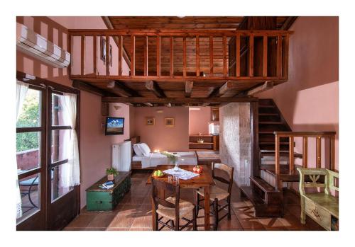 a living room with a loft with a table at Enagron Ecotourism Village in Axós