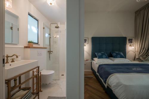 1 dormitorio con 1 cama y baño con lavamanos en VELLER Ben Yehuda, en Tel Aviv