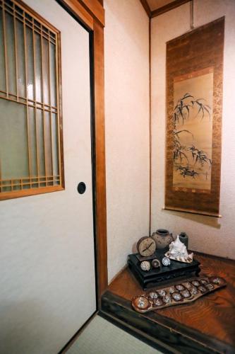 a room with a door and a shelf with items at Bighem Maison in Izumi-Sano