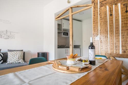 Graça Charming Apartment في لشبونة: طاولة عليها زجاجة من النبيذ والفواكه