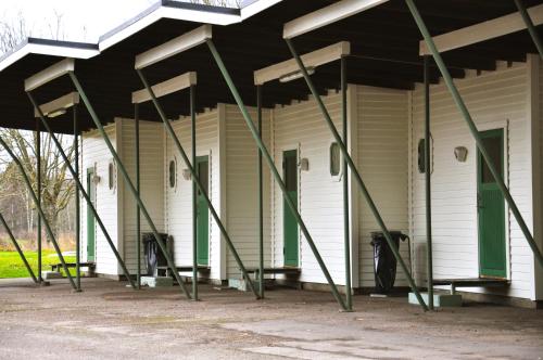 a white building with green poles in front of it at Sjögestad Motell in Vikingstad