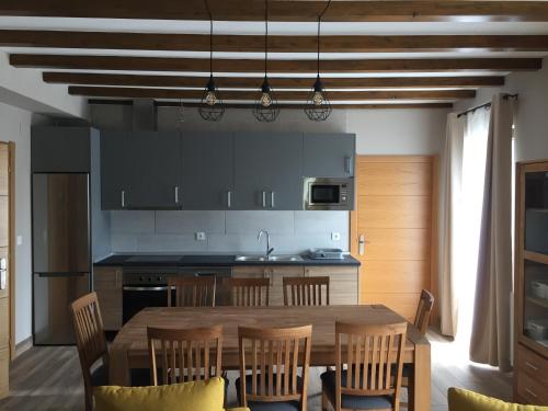a kitchen with a wooden table and a dining room at ETXEARTZI in Arciniega