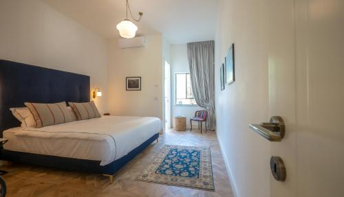 a bedroom with a bed with a blue headboard at VELLER Yehuda Halevi in Tel Aviv