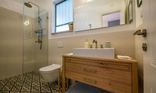 ein Badezimmer mit einem Waschbecken, einem WC und einem Spiegel in der Unterkunft VELLER Yehoshua Ben Nun in Tel Aviv