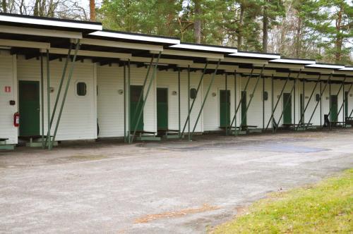 a white building with green doors and a roof at Sjögestad Motell in Vikingstad