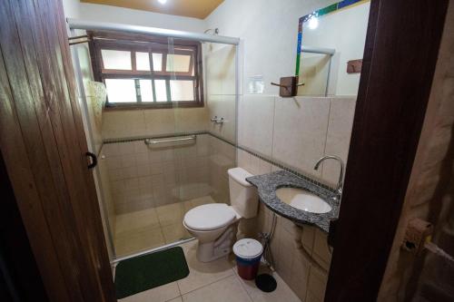 a small bathroom with a toilet and a sink at Pousada Aruana in Cavalcante