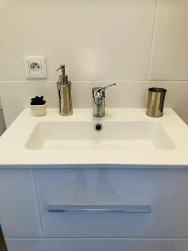 un lavabo blanc avec deux tasses en haut dans l'établissement Charmant studio proche Palais des festivals - Marché Forville, à Cannes