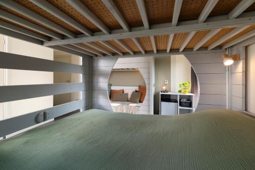 a bedroom with a bed and a mirror at Rufus aan het water in Broek