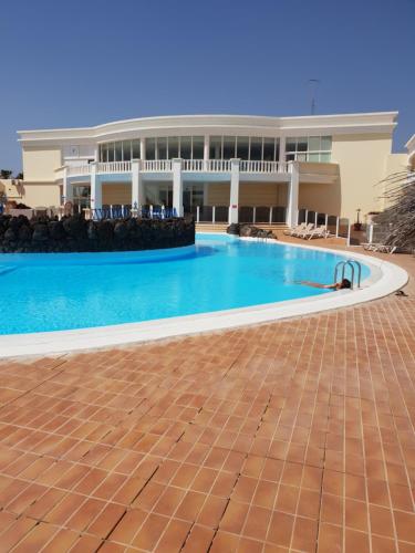 una piscina di fronte a un edificio di The Palms Golf del Sur a San Miguel de Abona