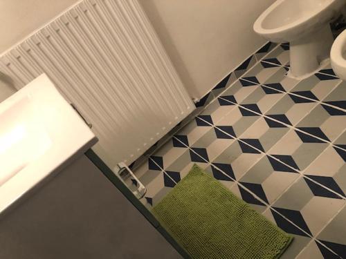 Łazienka z umywalką i toaletą oraz podłogą wyłożoną kafelkami w obiekcie Appartement donnant sur jardin avec terrasse. w mieście La Roche-sur-Yon