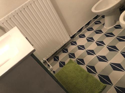 La salle de bains est pourvue d'un lavabo, de toilettes et de carrelage. dans l'établissement Appartement donnant sur jardin avec terrasse., à La Roche-sur-Yon