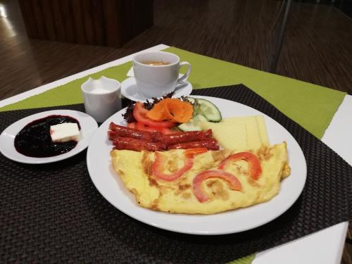 a plate of food on a table with a cup of coffee at Pensiunea Happy Inn in Vatra Dornei