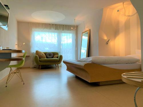 1 dormitorio con 1 cama grande y 1 silla en hotelmärchen Garni, en Ludwigsburg