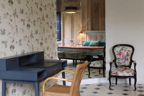 een kamer met een bureau en stoelen en een slaapkamer bij Tourisme et Affaires Quimper + parking privé, wifi, jardin in Quimper