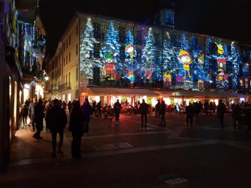 a group of people walking down a street with christmas lights at Residence SANTABBONDIO in Como