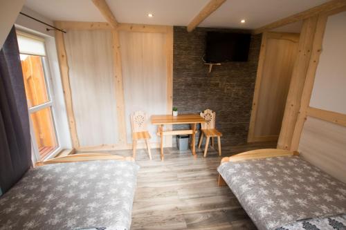 a room with two beds and a table and chairs at Noclegi u Gabrysi in Kościelisko