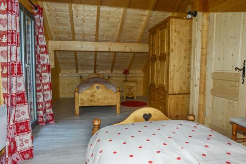 1 dormitorio con 1 cama en una cabaña de madera en Chalet Flocon, en Plénise