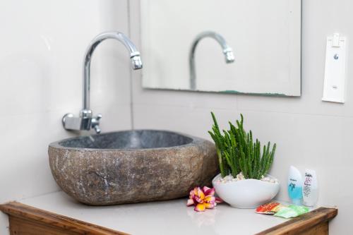 a bathroom sink with two faucets on a counter at Arjuna Bungalow in Nusa Penida