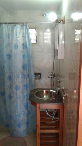 ein Badezimmer mit Waschbecken und Duschvorhang in der Unterkunft Bungalow Montes in El Bolsón