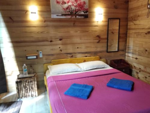 a bedroom with a large pink bed with wooden walls at Samsun Pride in Chaoka