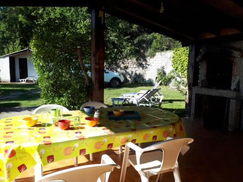 a table with a yellow table cloth on a patio at DISCRET, APAISANT, CALME entre MER et MONTAGNE in Isolaccio-di-Fiumorbo