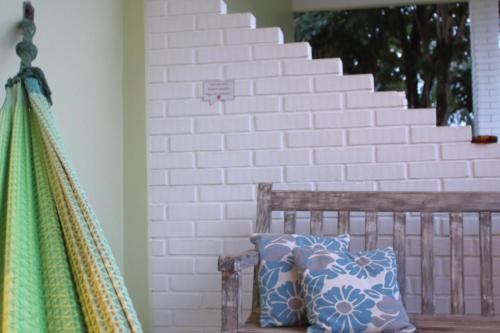 a wooden bench with a pillow and a wall at Pousada Tajupá in Pirenópolis