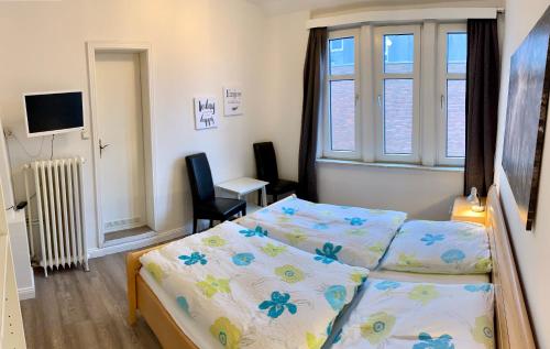 a bedroom with a bed and a desk and a window at Gästehaus Seewarte in Flensburg