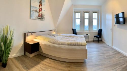 a bedroom with a bed and a table and chairs at Gästehaus Seewarte in Flensburg