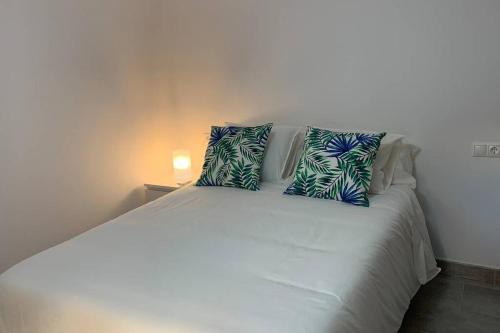 een wit bed met twee kussens erop bij RENOVATED HOUSE IN OLD TOWN MARBELLA. in Marbella