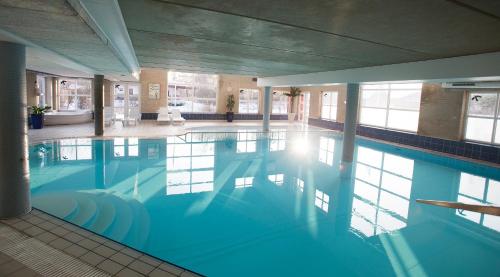 
a large swimming pool in a hotel room at Hotel Kommandørgården in Rømø Kirkeby
