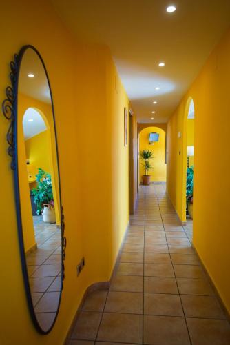 a hallway with a mirror on a yellow wall at Marquesa de las Jarras in Teruel
