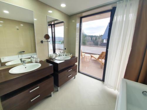 a bathroom with two sinks and a large mirror at Silver Fox Residence in Poiana Brasov