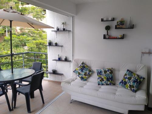 sala de estar con sofá blanco y mesa en Apartasol en Santa Fe de Antioquia Apartment, en Santa Fe de Antioquia