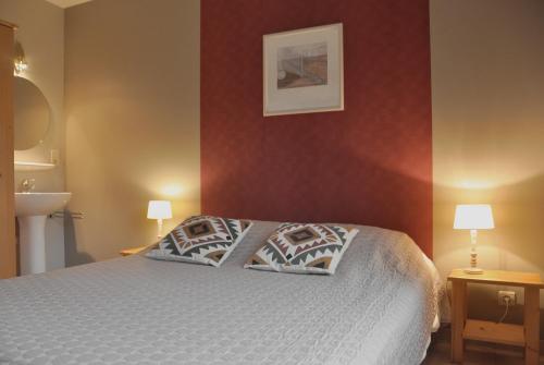 a bedroom with a bed with two pillows on it at Les Terriers Saint-Hubert in Hatrival
