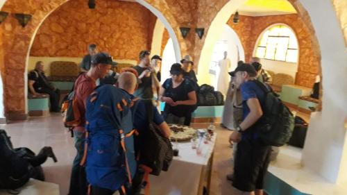 阿布辛貝的住宿－Hllol Hotel Abu Simbel，一群人站在桌子旁