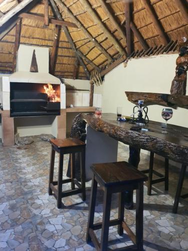 uma cozinha com lareira, mesa e banco em Lani's Guest House - No Loadshedding em Musina