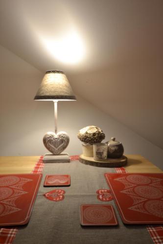 a table with a lamp and a table with red mats at Golden Mountain in Karpacz