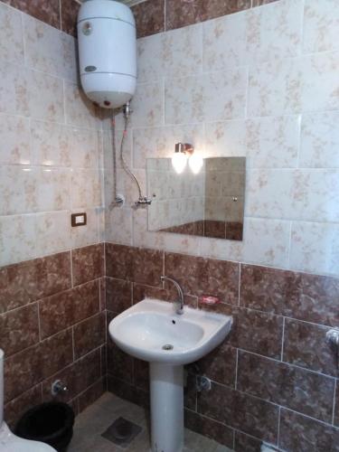 a bathroom with a white sink and a mirror at Hllol Hotel Abu Simbel in Abu Simbel