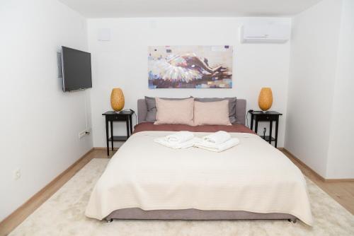 a bedroom with a large white bed with two night stands at Dreamy Garden Zagreb in Zagreb