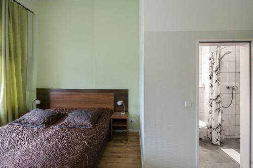 a bedroom with a bed and a bathroom with a shower at Pension Classic in Berlin